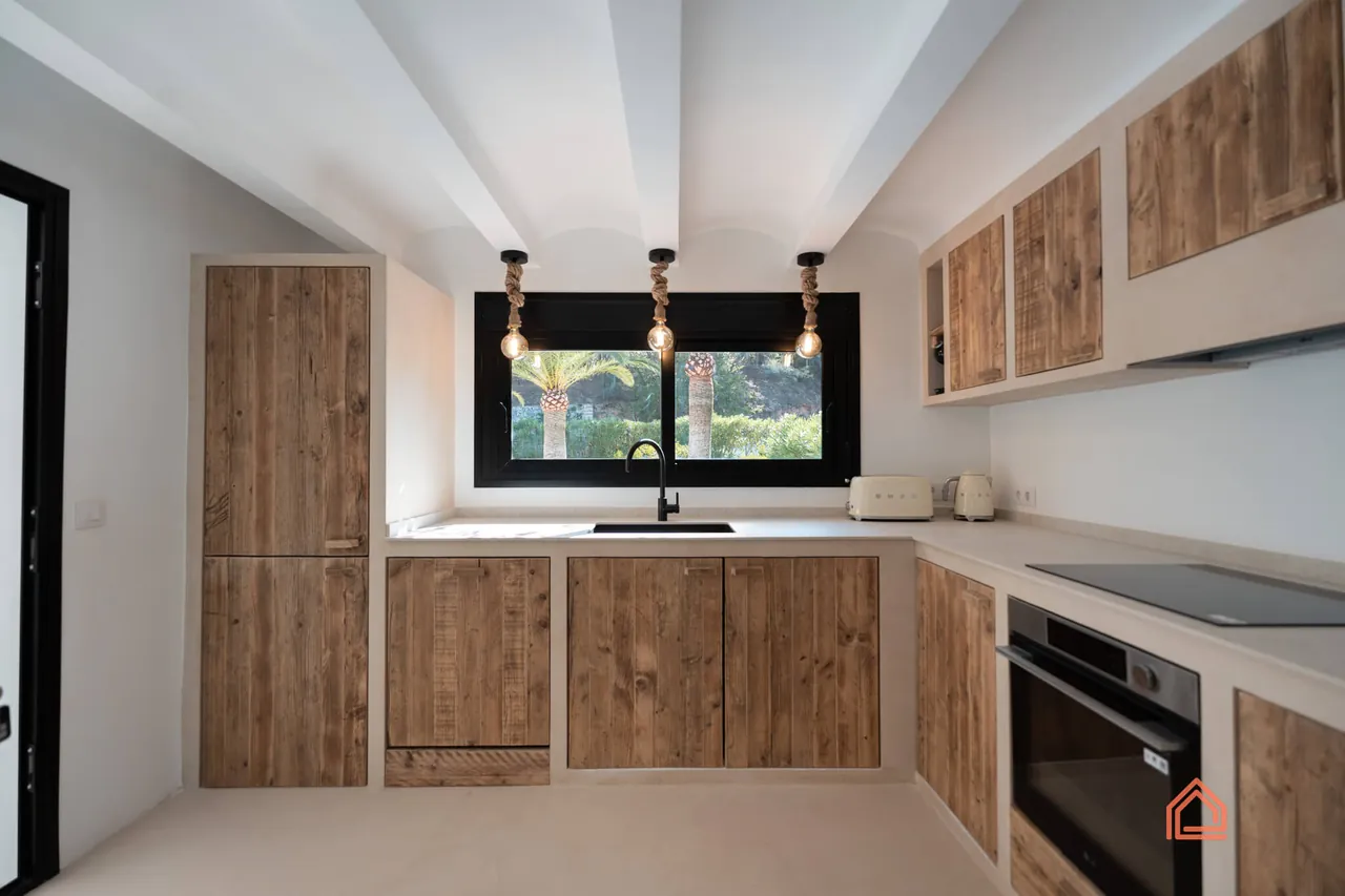 Reclaimed wood kitchen with pendant lights above the sink window